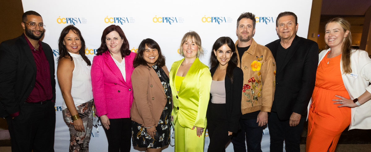 group of PRSA members in front of PRSA logo wall