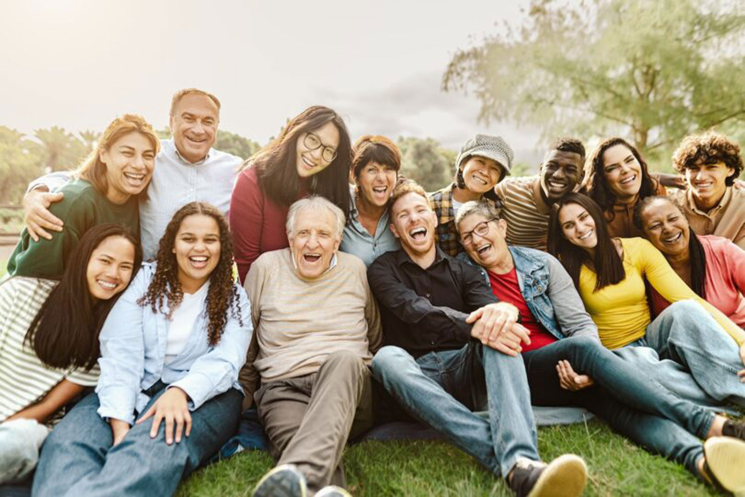 group of adults sitting on grass lawn