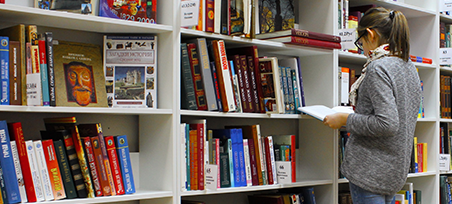 Person sorting through books for a glossary of terms.