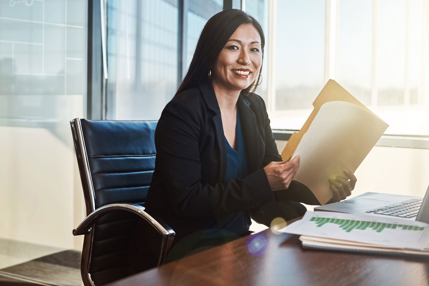 professional woman at desk holding a file  folder