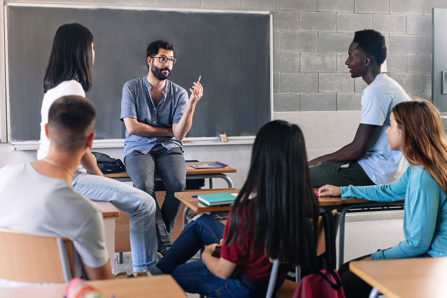 professor with students in front of blackboard