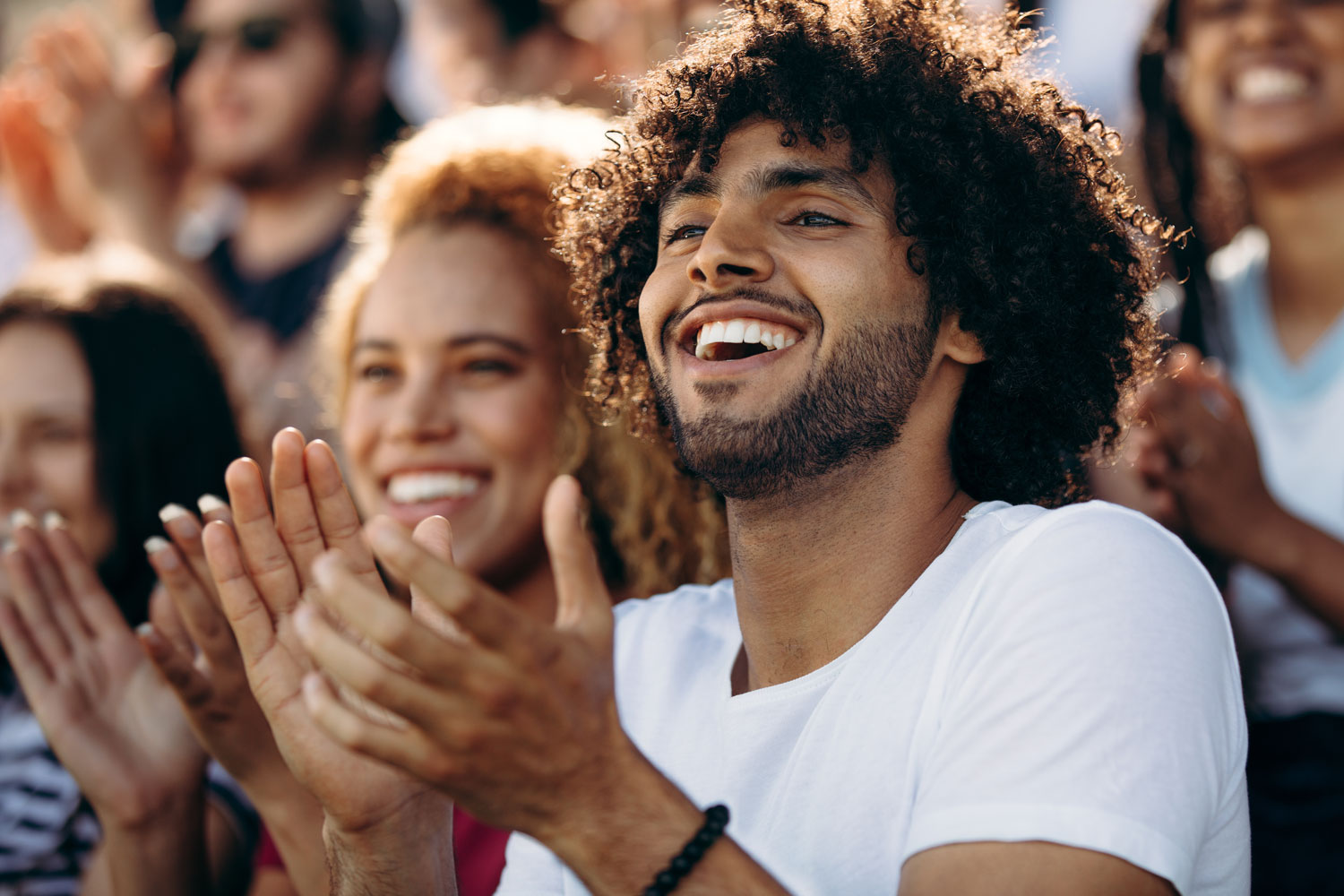 young couple in large audience clapping hands