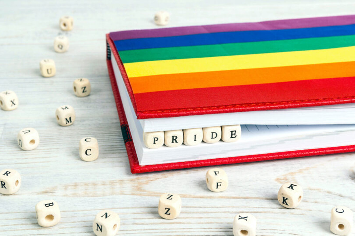 blocks spelling pride in rainbow colored notebook