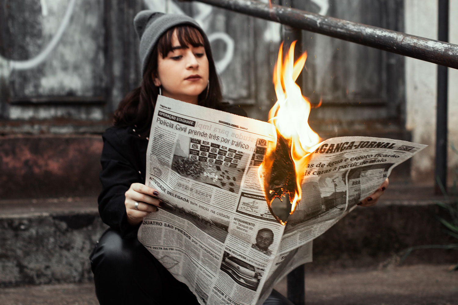 young women reading newspaper in flames