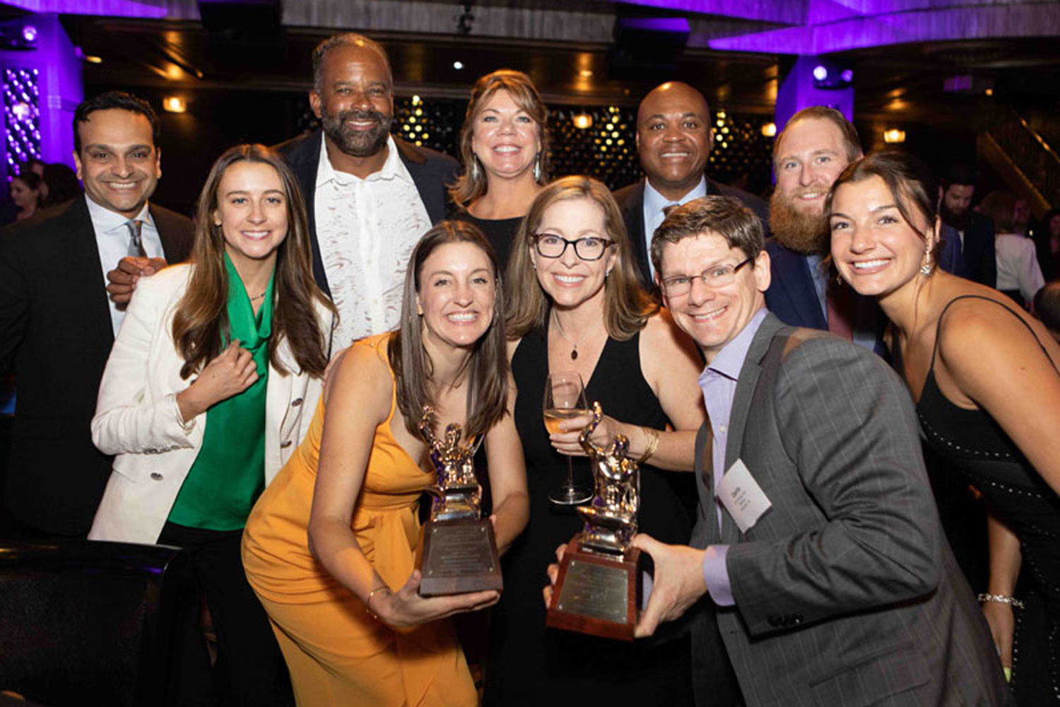 group of professionals holding awards trophies