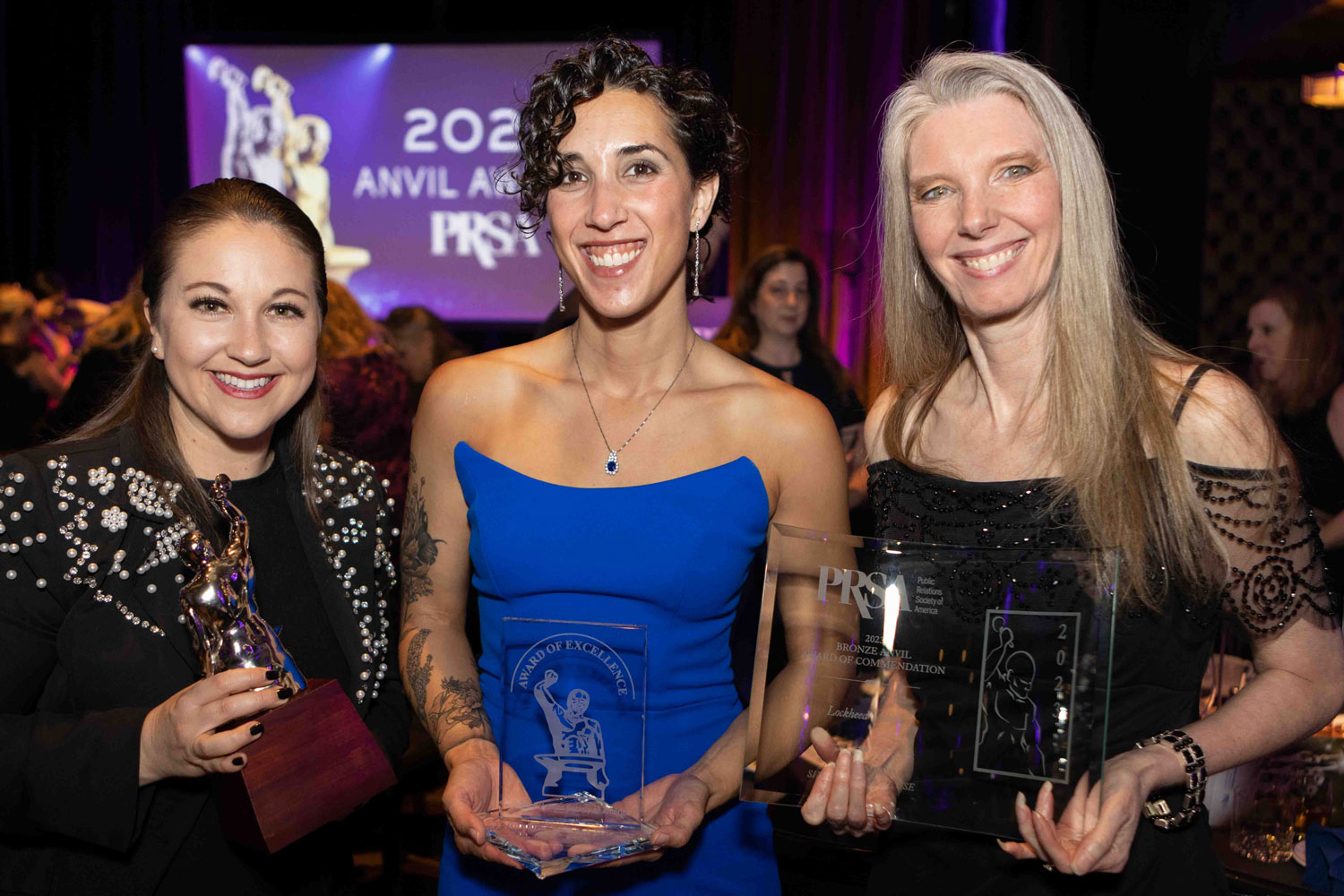 three women holding award trophies