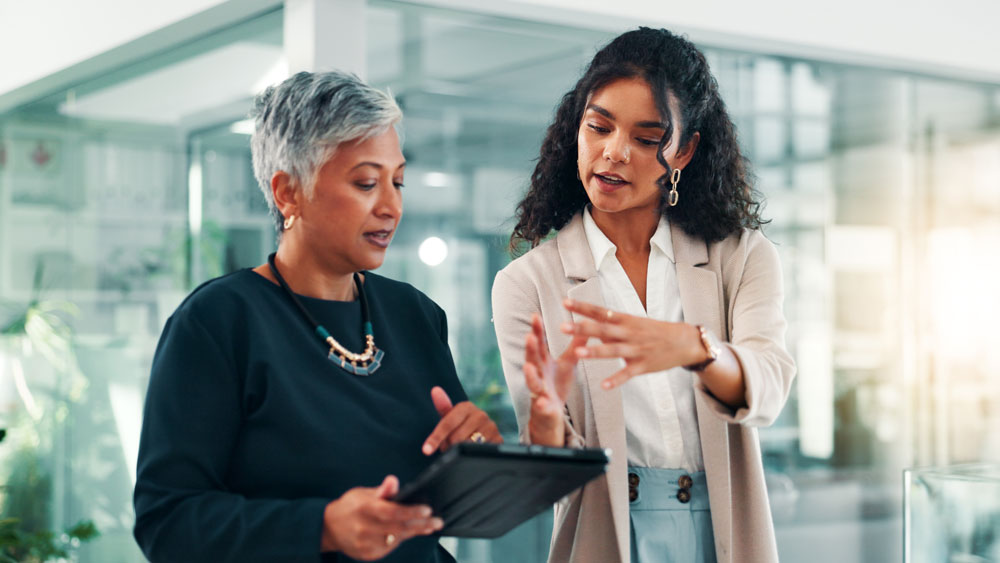 two women looking at content on tablet computer