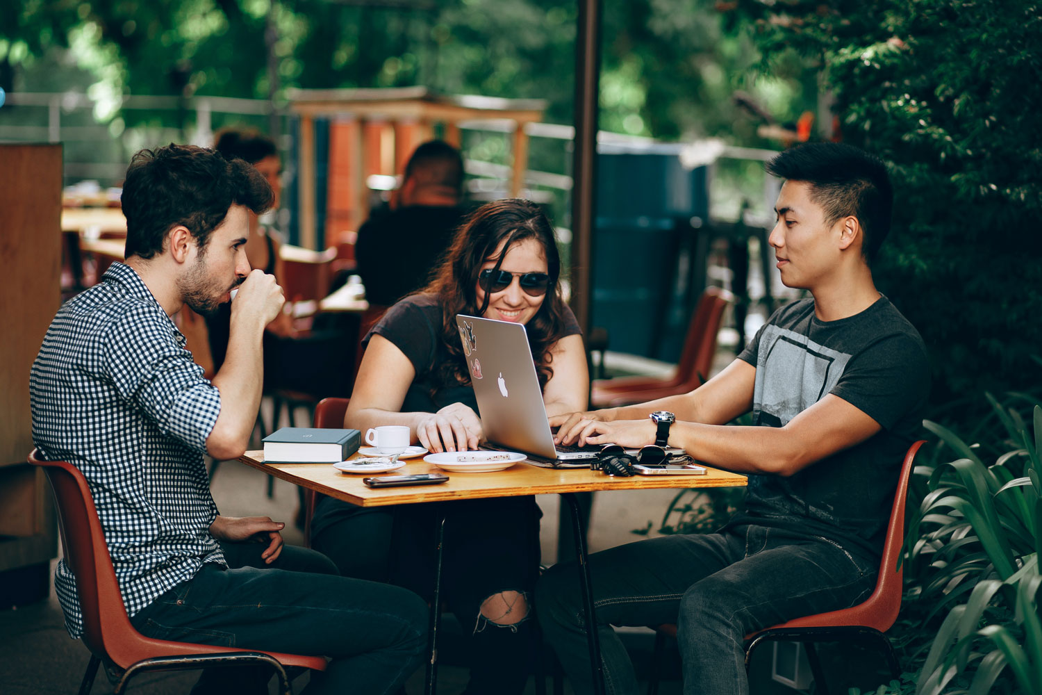 Three people in coffee shop with laptop