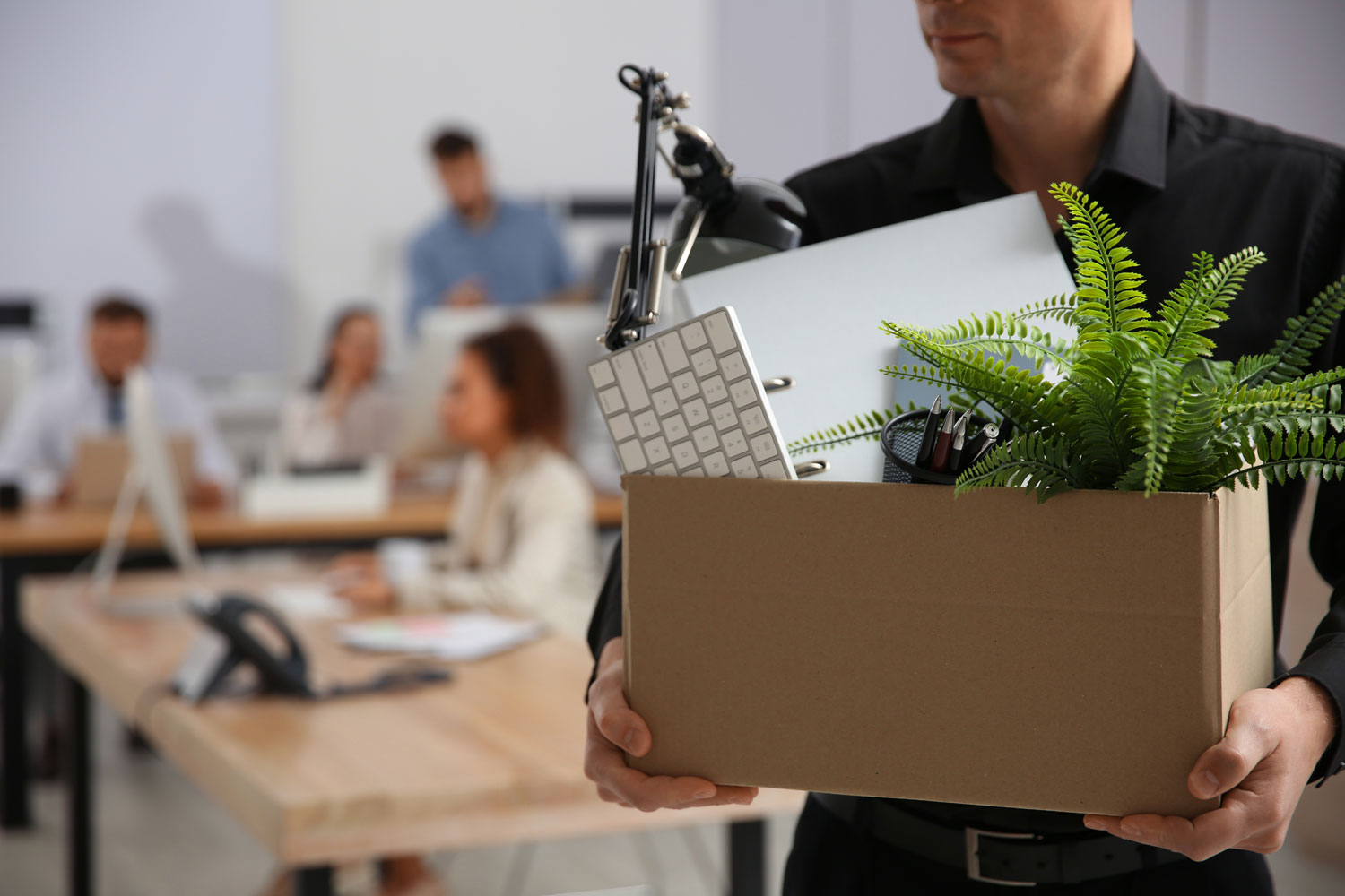 man carrying cardboard box with office items